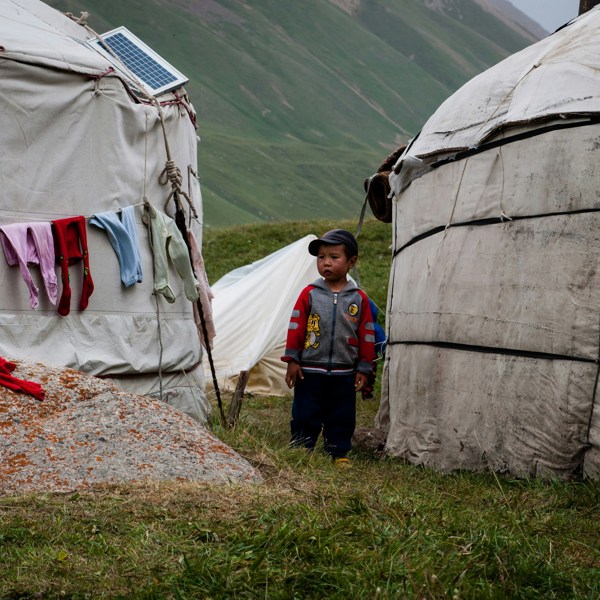 Kirgisisk dreng står mellem to hytter