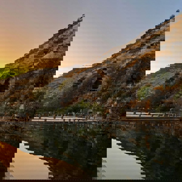 Solnedgang over bjerglandskab i Salalah, Oman