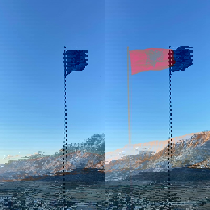 Udsigt over bjergene med Albaniens flag i forgrunden