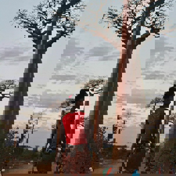 girl walking in between babaotræer